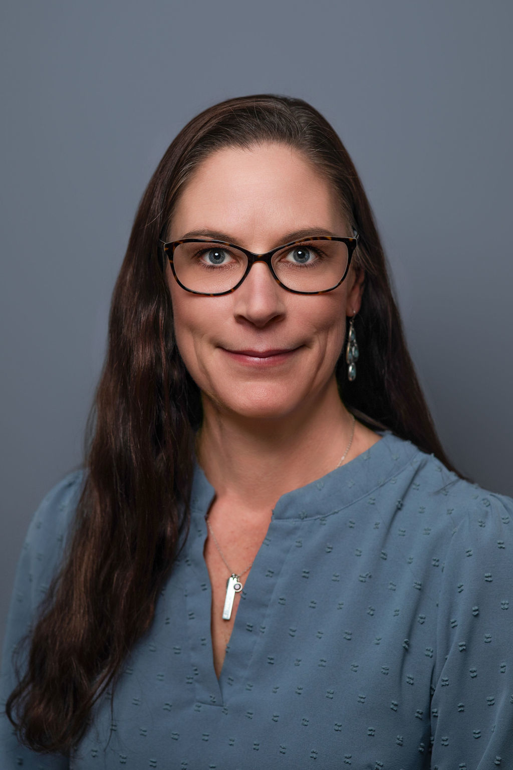 Professional headshot of woman wearing glasses