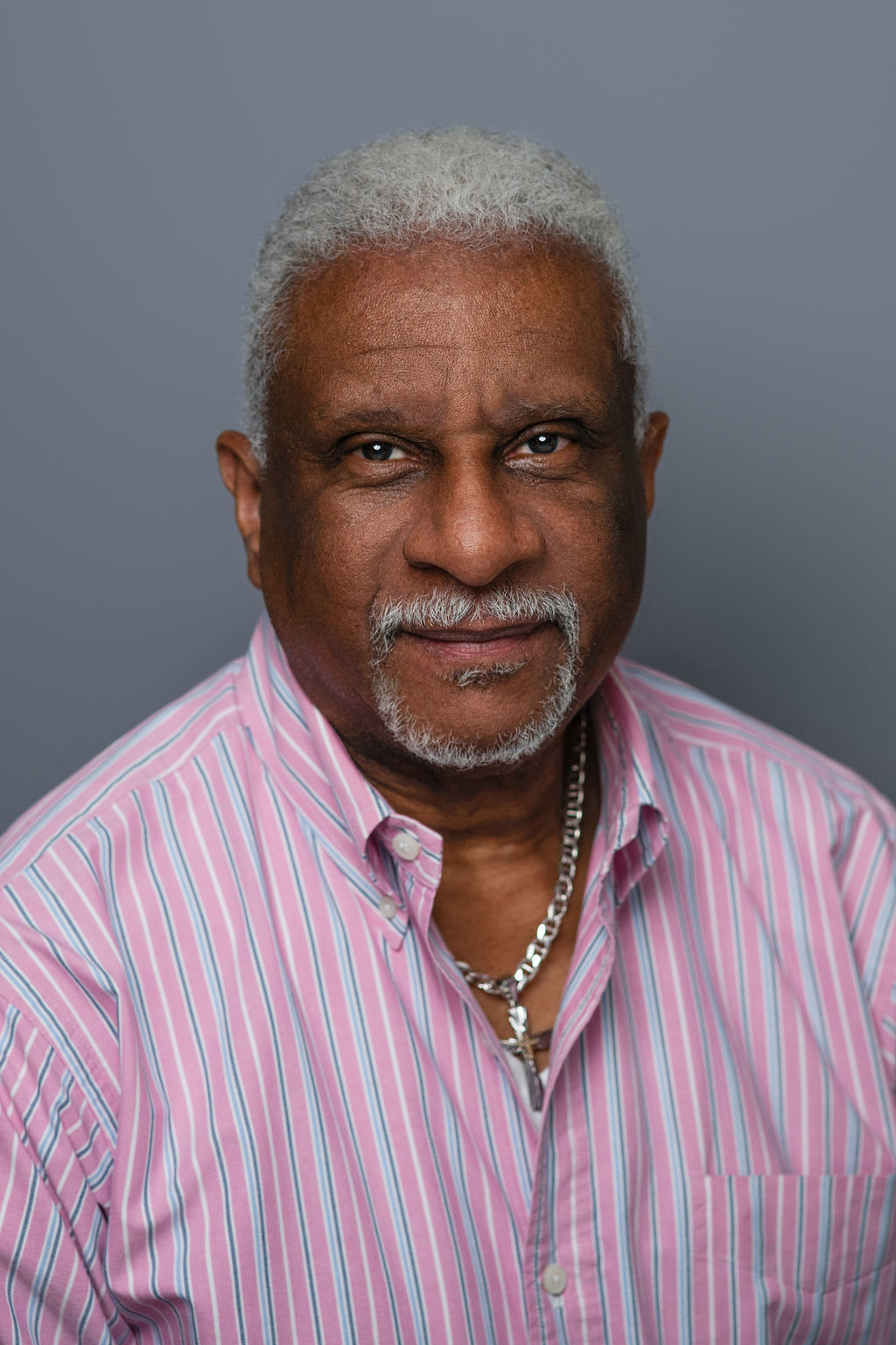 Portrait of older man in pink striped shirt