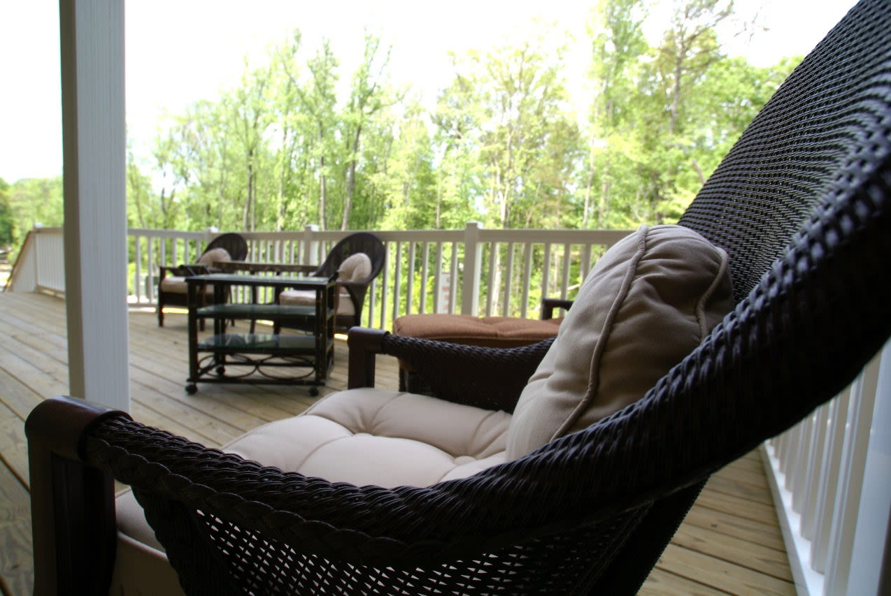 Wicker chairs on covered porch with forest view
