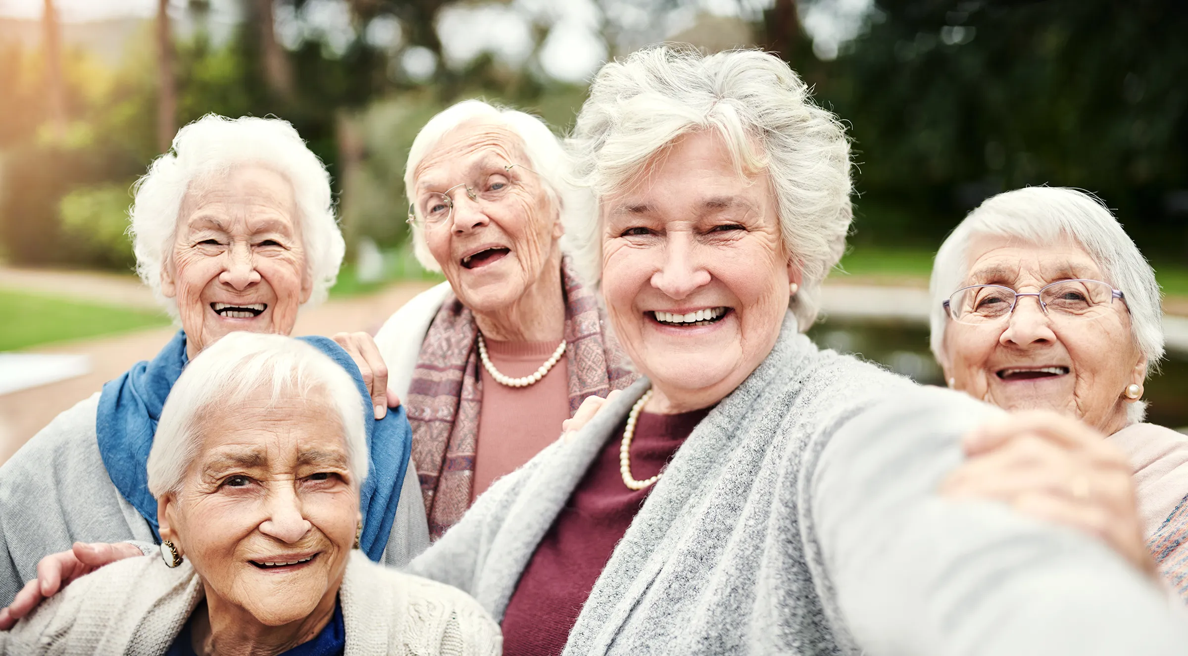 Five elderly women smiling for outdoor selfie