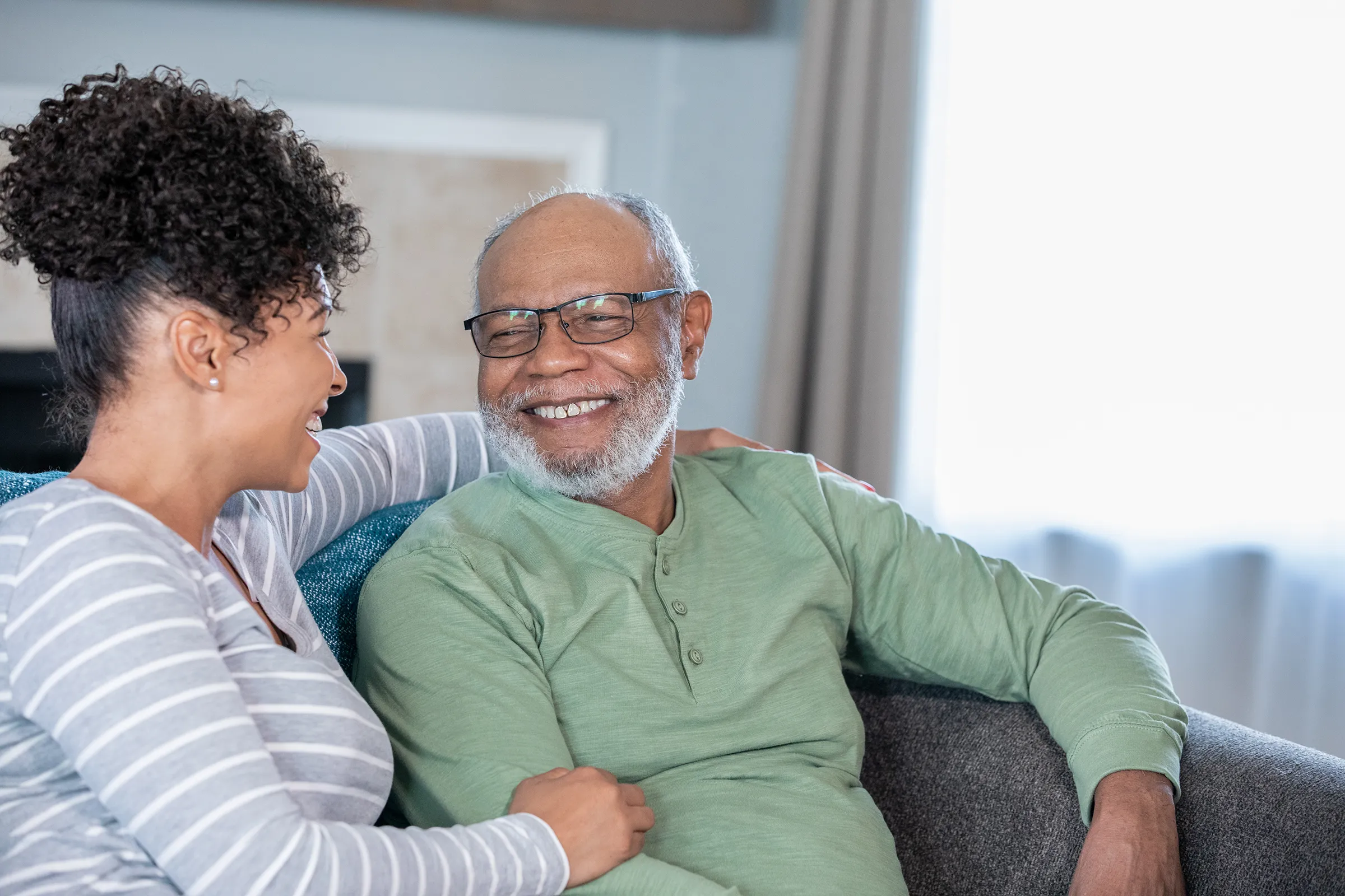 Smiling older man and woman chatting on couch